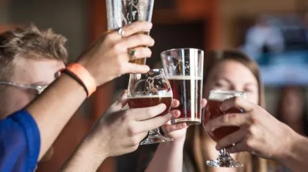 Friend raising glasses of beer to cheers